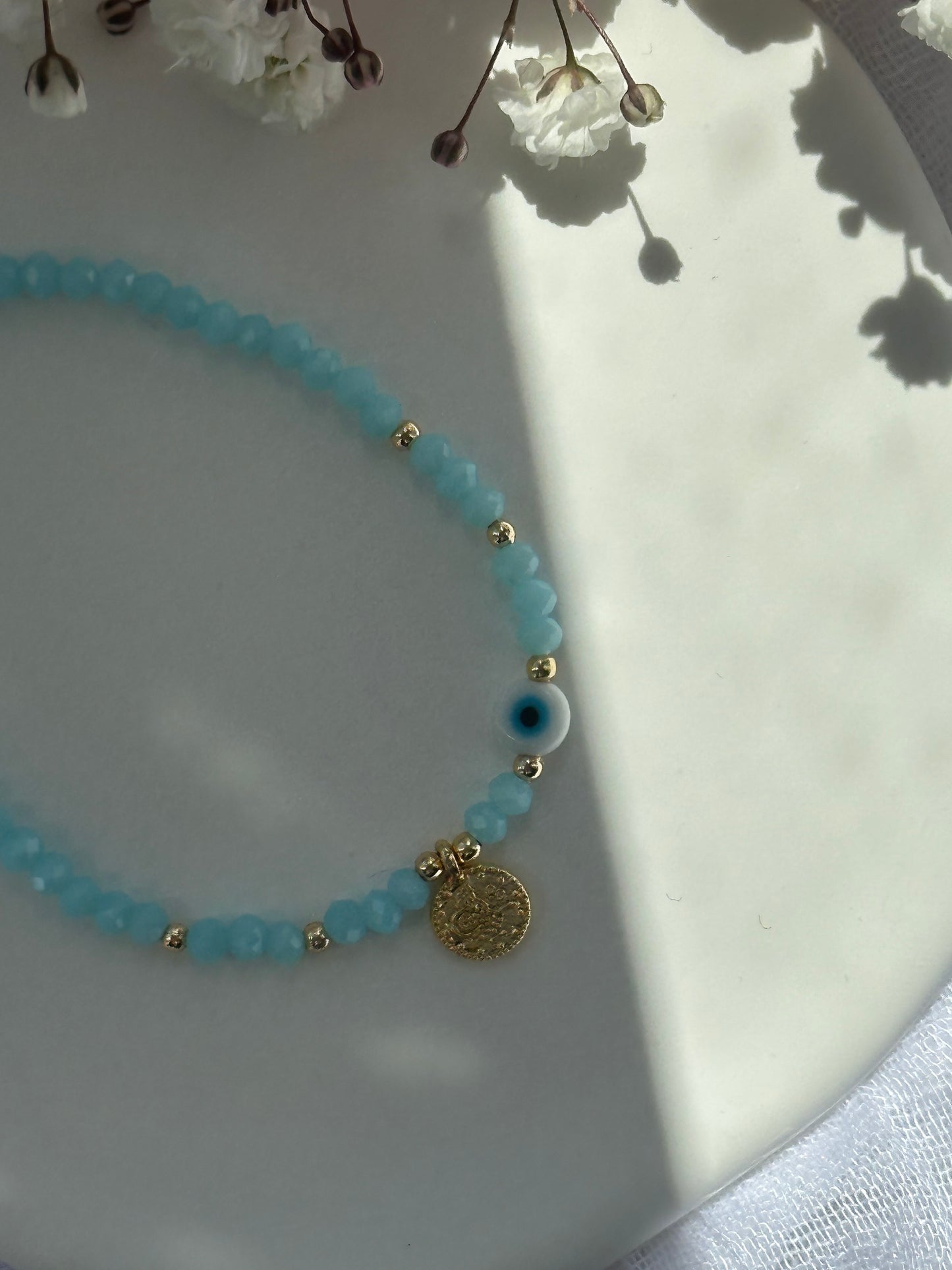 Perlenarmband mit Hellblauen Kristallperlen und goldenen Details+ Nazar und Goldener Taler Anhänger - 10747