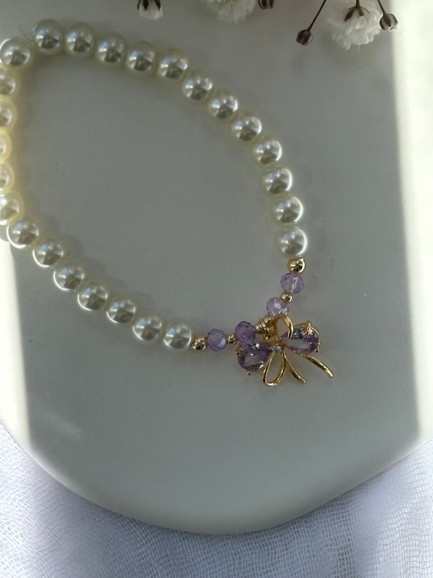 Perlenarmband mit Beigen Glasperlen und goldenen Details + Lila Schleifen Anhänger - 10721