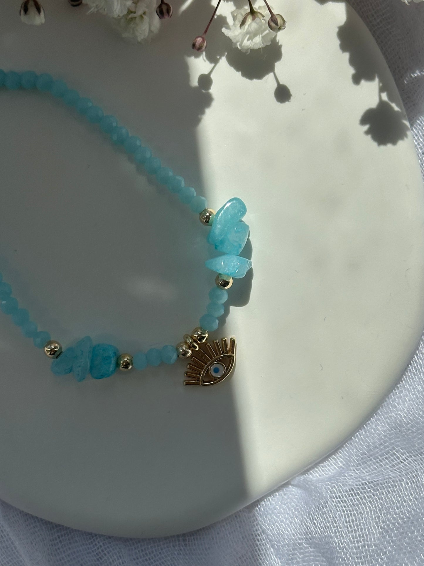 Perlenarmband mit Hellblauen Kristallperlen und Blauen Natursteinen und goldenen Details + Nazar Anhänger - 10750