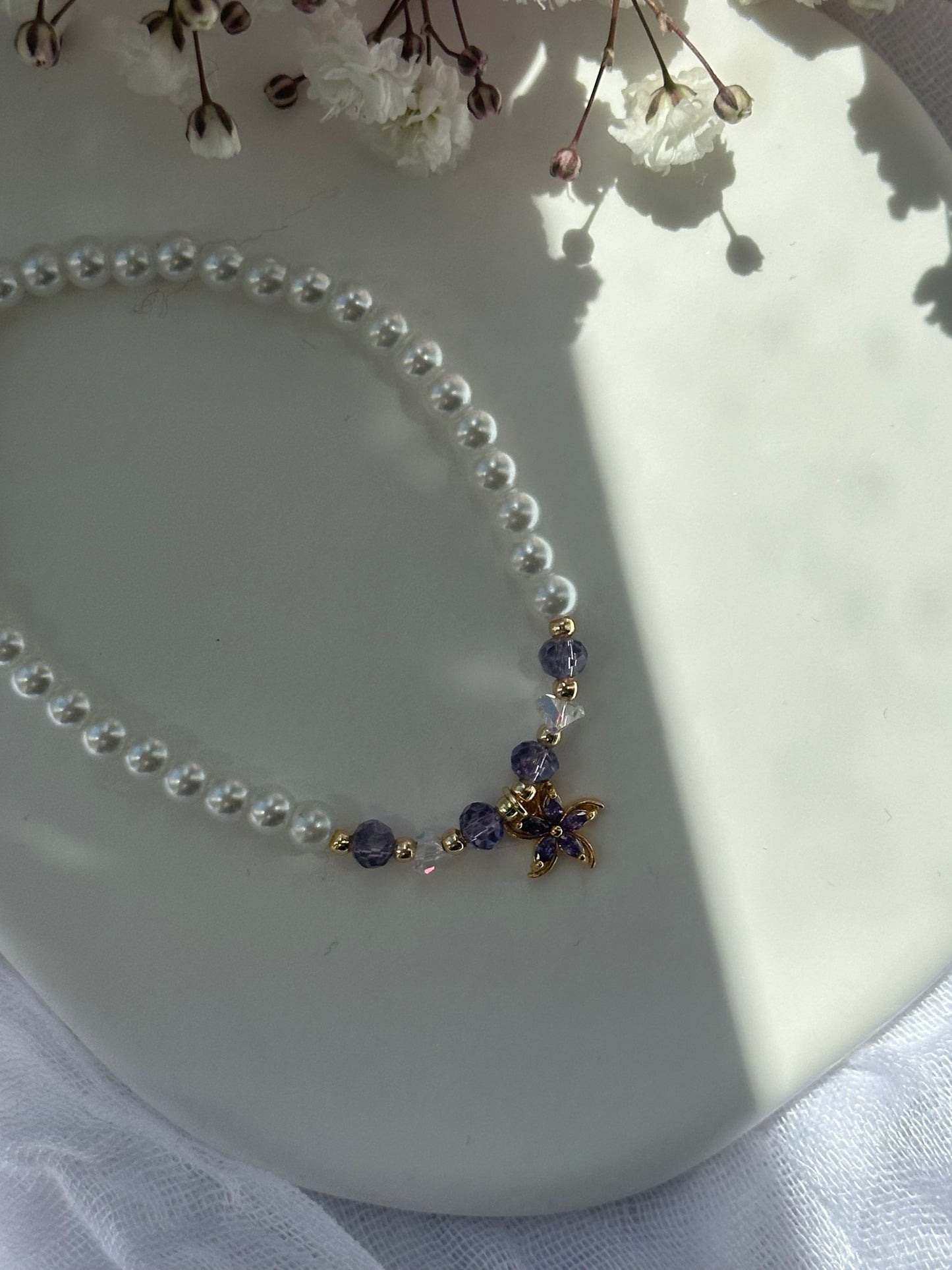 Perlenarmband mit Weißen Glasperlen und Lila Kristallperlen und goldenen Details + Blumen Anhänger - 10724