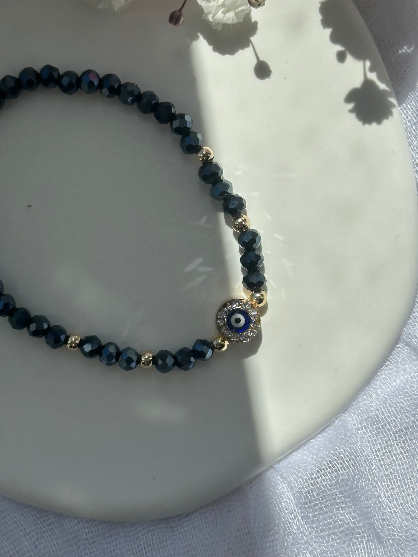 Perlenarmband mit Dunkelblauen Kristallperlen und goldenen Details + Zirkonia Nazar Anhänger - 10749