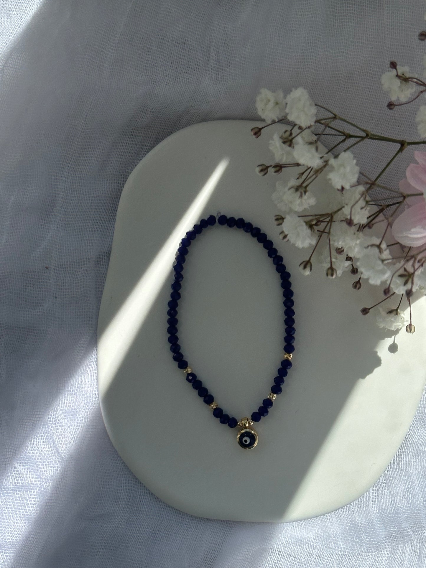 Perlenarmband mit Dunkelblauen Kristallperlen und goldenen Details + Nazar Anhänger - 10765