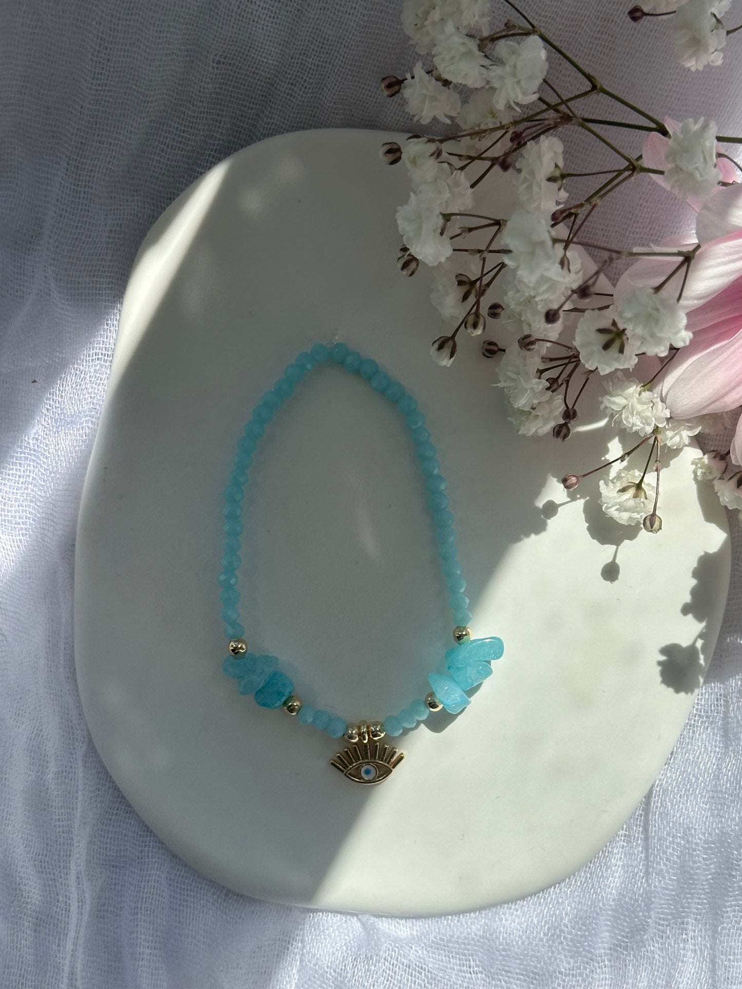 Perlenarmband mit Hellblauen Kristallperlen und Blauen Natursteinen und goldenen Details + Nazar Anhänger - 10750