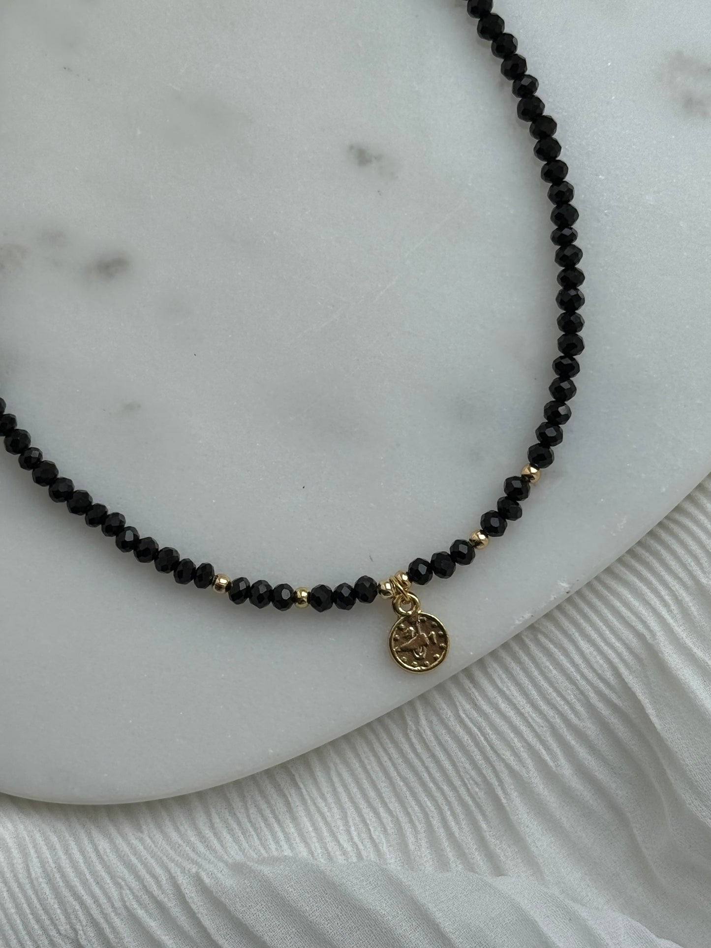 Perlenkette mit Schwarzen Kristallperlen, Goldenen Details + Taler Anhänger - 111162