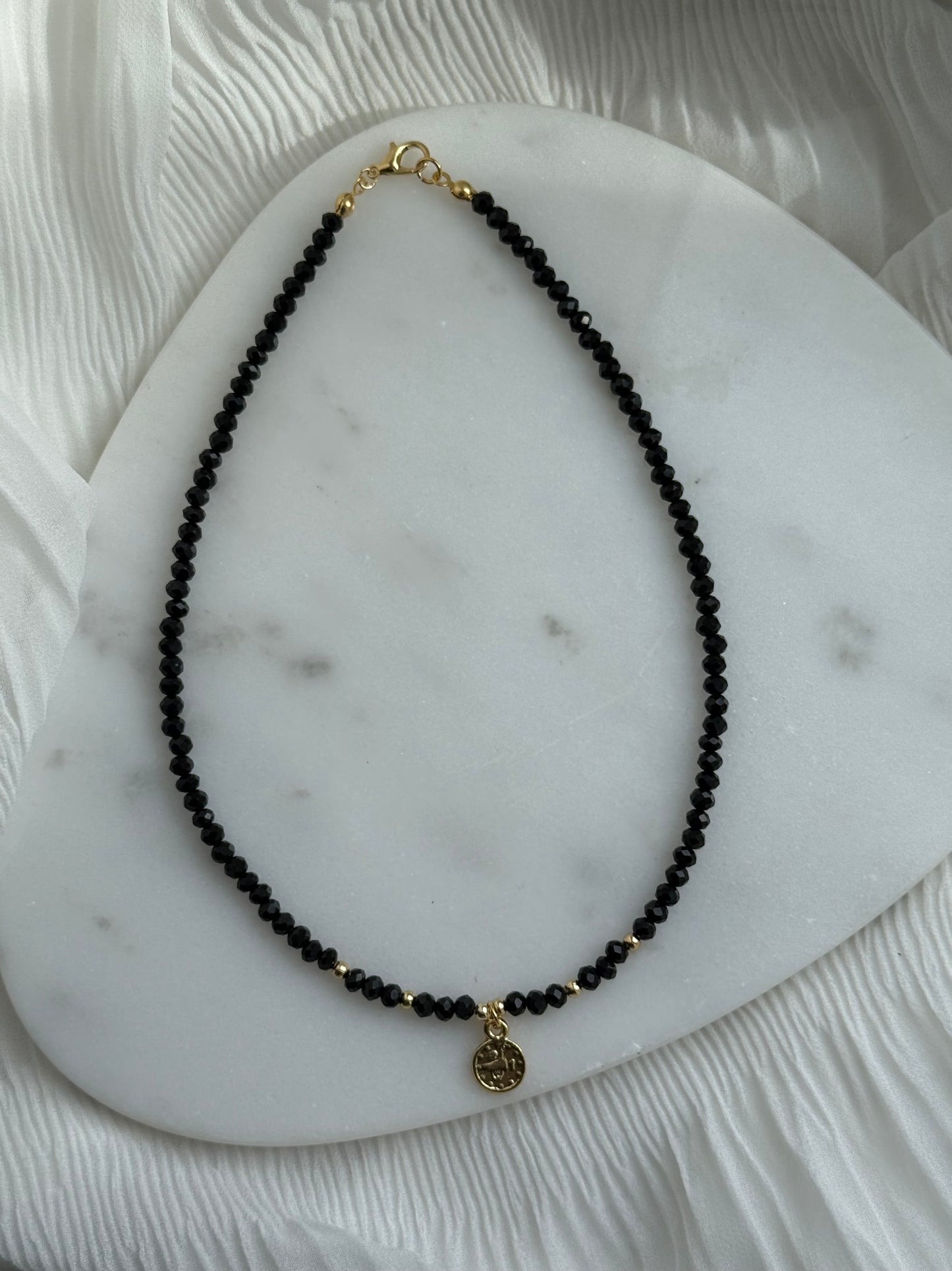 Perlenkette mit Schwarzen Kristallperlen, Goldenen Details + Taler Anhänger - 111162