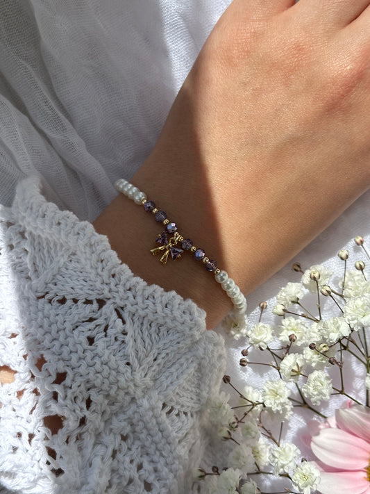 Perlenarmband mit Weißen Glasperlen und Lila Kristallperlen und goldenen Details + Schleifen Anhänger - 10733