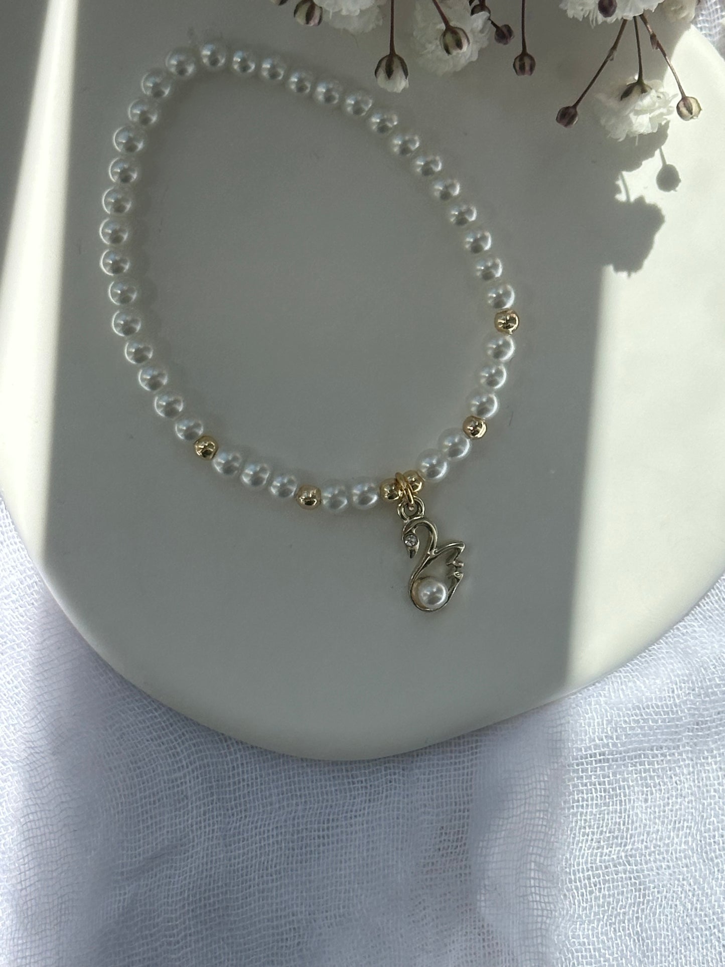 Perlenarmband mit Weißen Perlen und goldenen Details + Schwan Anhänger - 10717