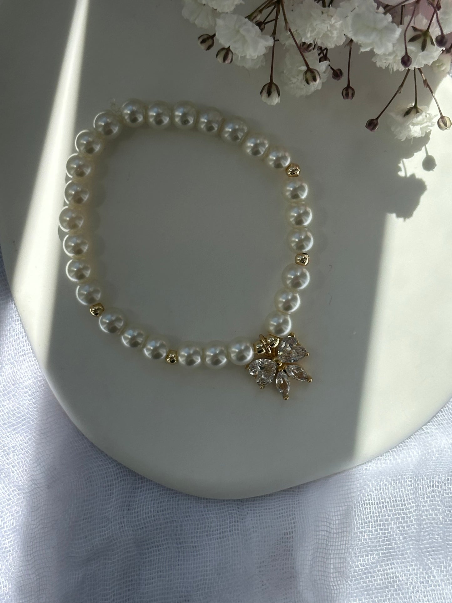 Perlenarmband mit Beigen Glasperlen und goldenen Details + Zirkonia Schleifen Anhänger - 10736