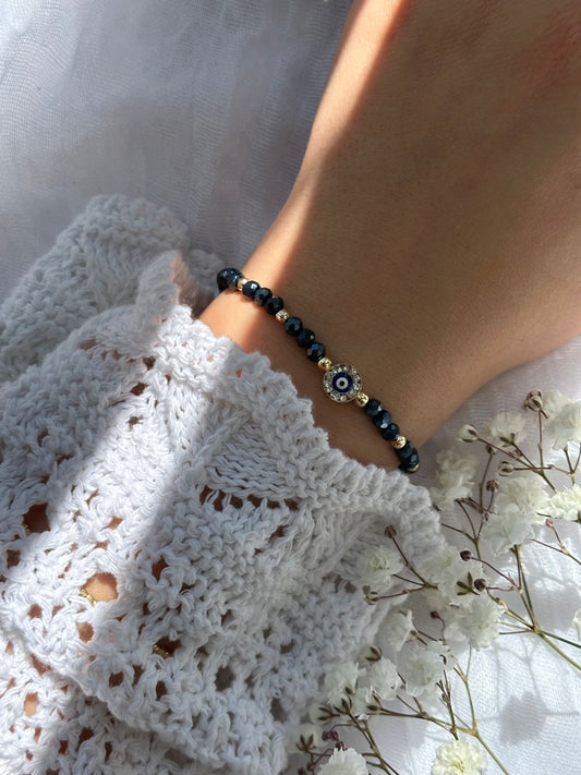 Perlenarmband mit Dunkelblauen Kristallperlen und goldenen Details + Zirkonia Nazar Anhänger - 10749