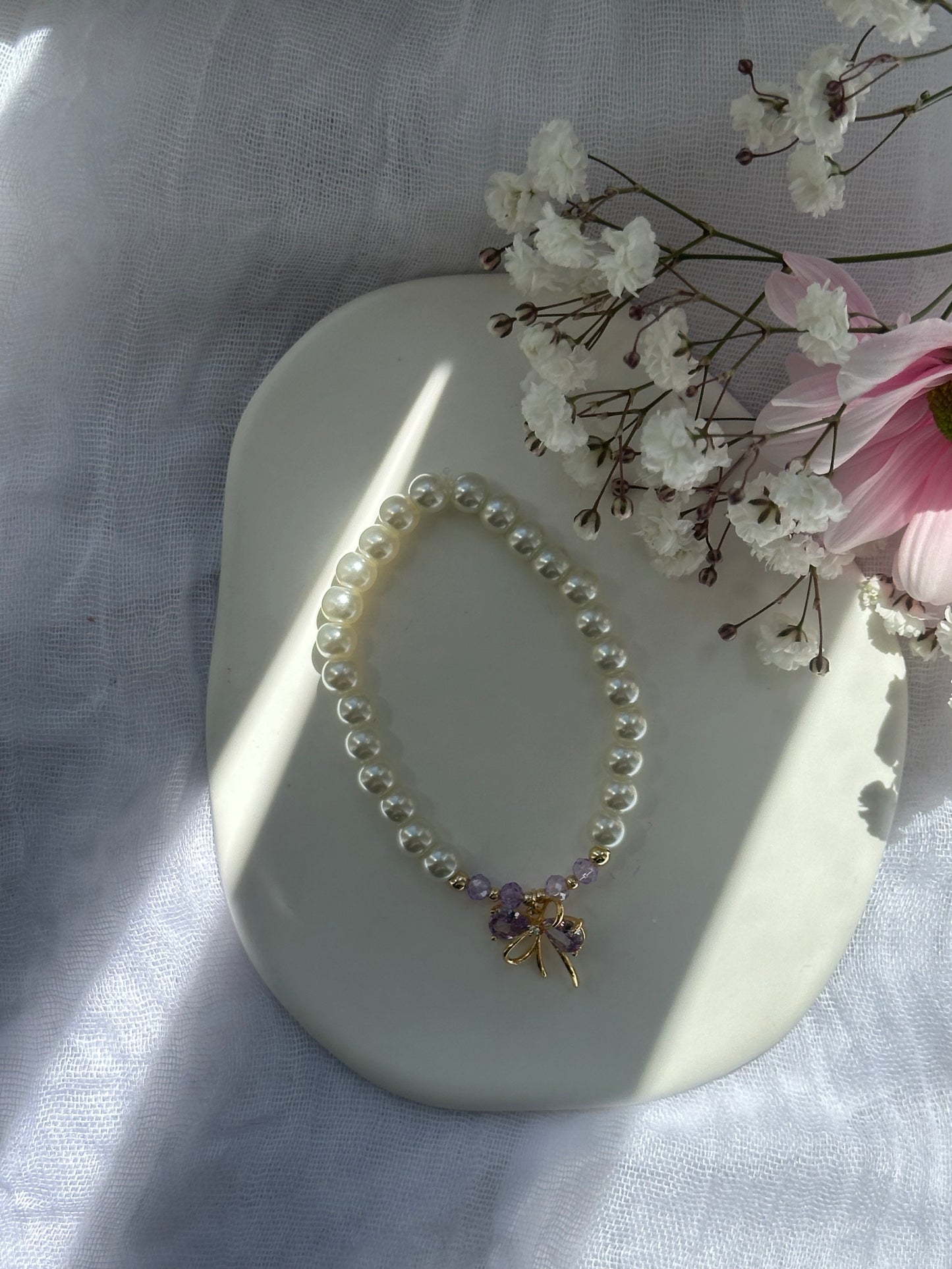 Perlenarmband mit Beigen Glasperlen und goldenen Details + Lila Schleifen Anhänger - 10721