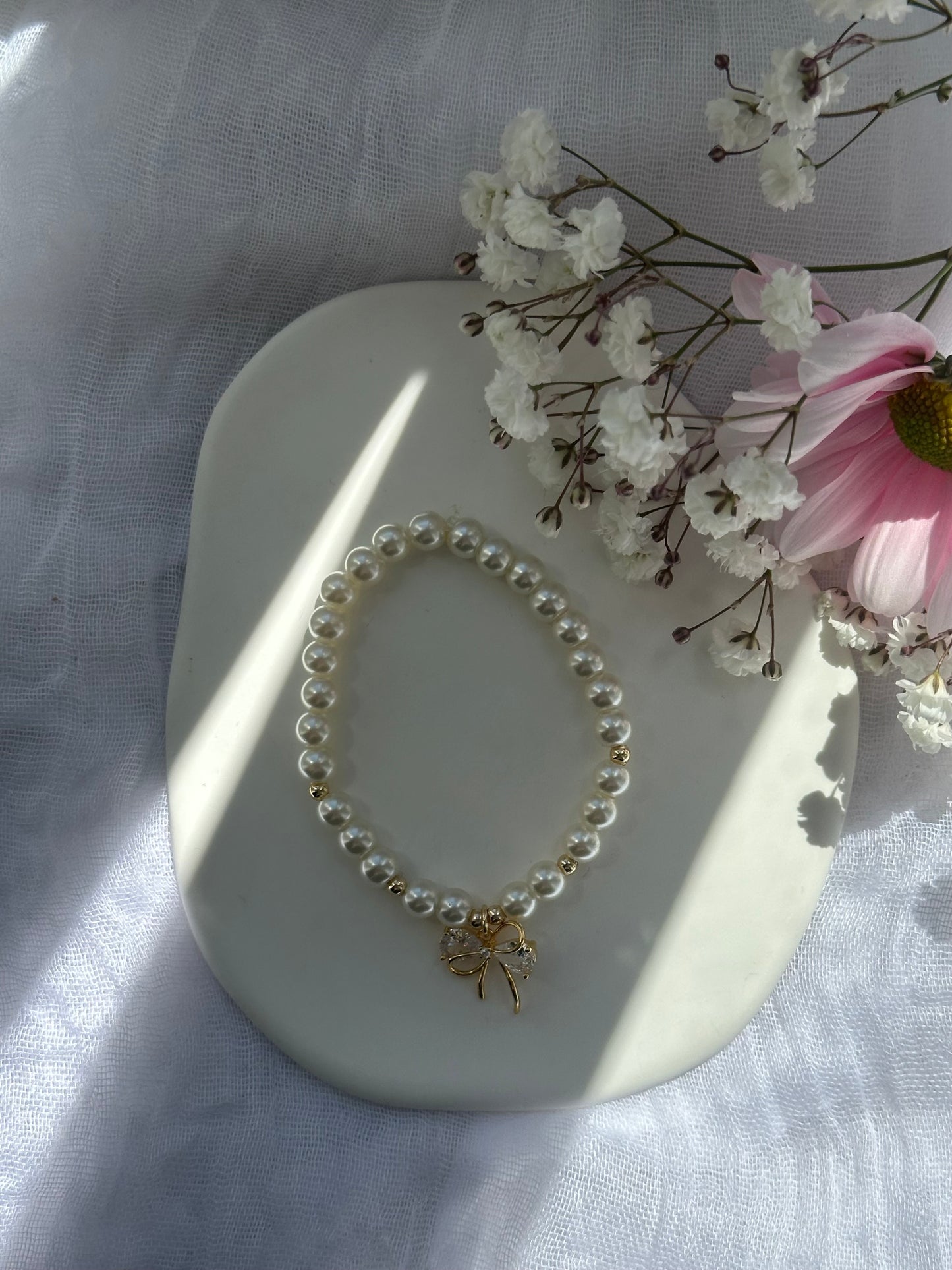 Perlenarmband mit Beigen Glasperlen und goldenen Details + Schleifen Anhänger - 10726